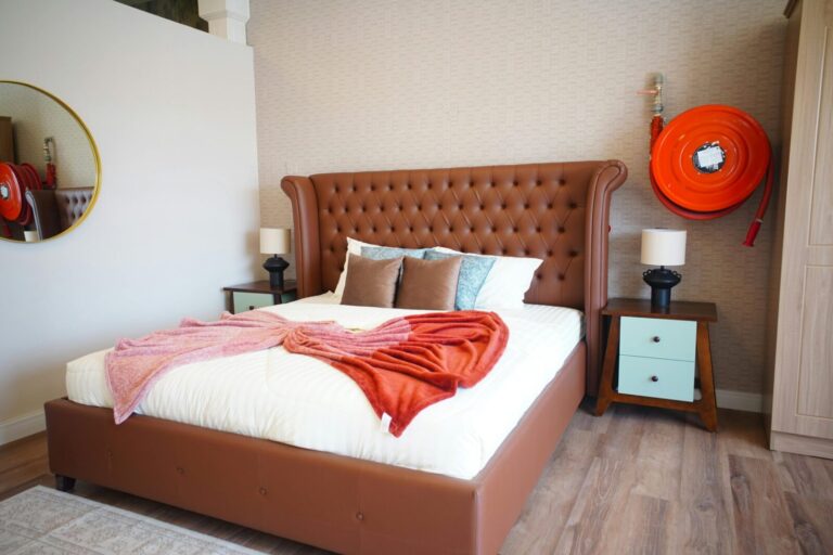Elegant bedroom with tufted leather headboard and cozy decor in neutral tones.